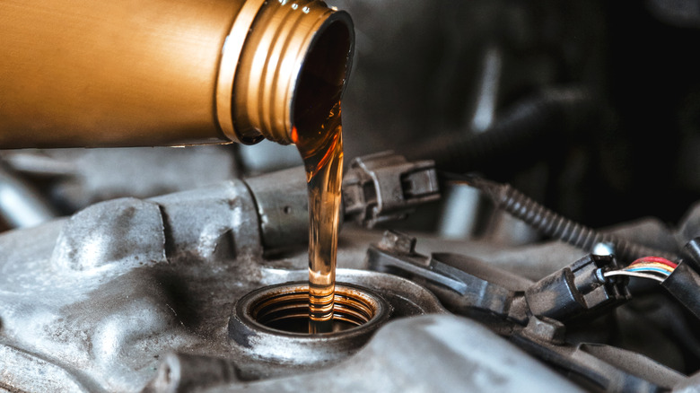 Pouring oil into engine