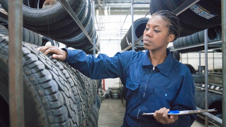 A tire technician inspecting used vehicle tires