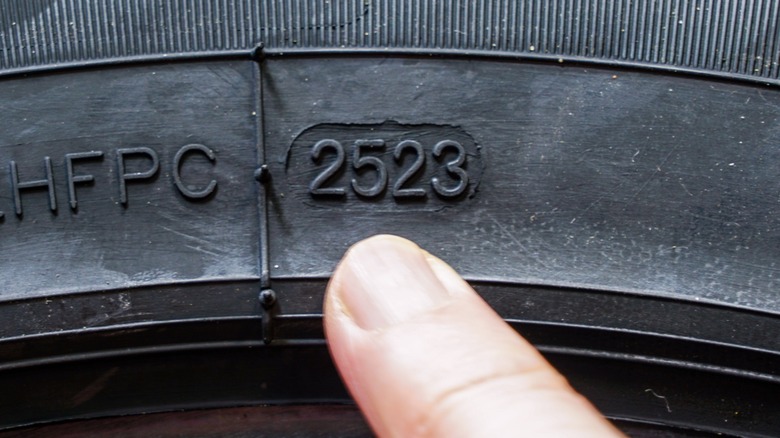 Pointing out the date code on a tire following the DOT TIN