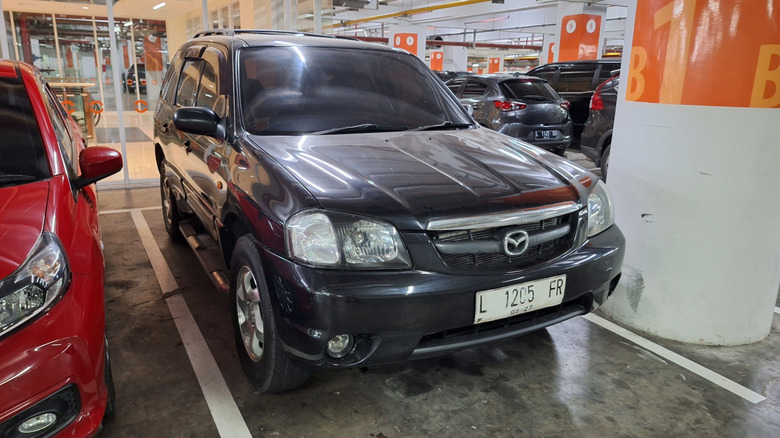 Front view of a black Mazda Tribute snapped in a parking lot