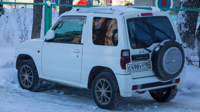 The rear of a white Mitsubishi Pajero Mini parked outside during winter