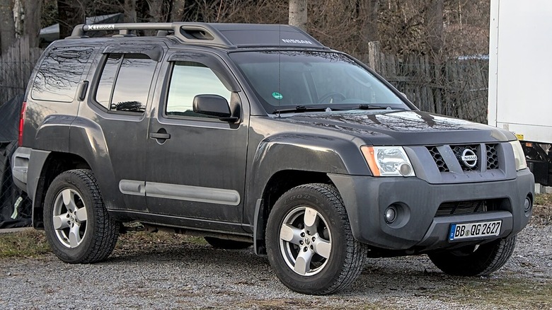 Grey Nissan Xterra parked on gravel driveway