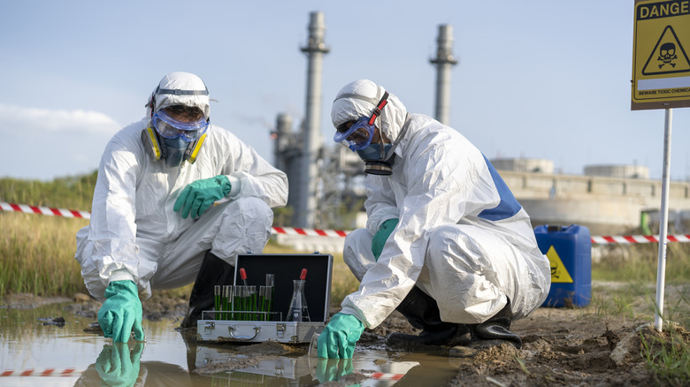 People in Hazmat suits testing water near a power plant