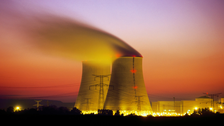 Nuclear power plants at sunset with vapor coming out of the smokestacks