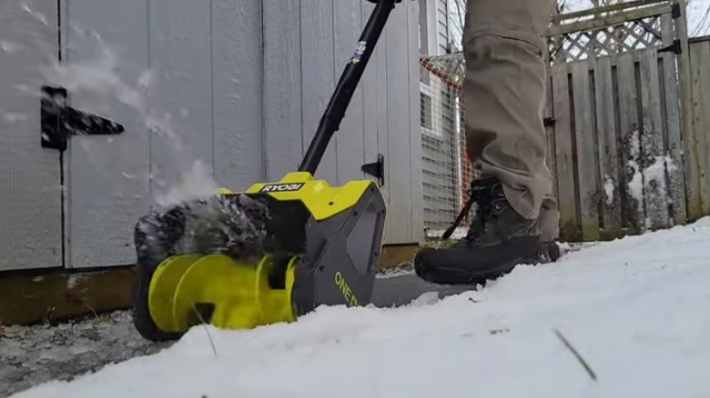 Person using electric snow shovel