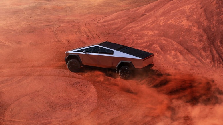 Cybertruck being driven amidst red sand