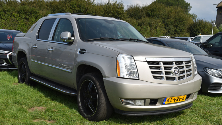 Silver Cadillac Escalade EXT parked on the grass