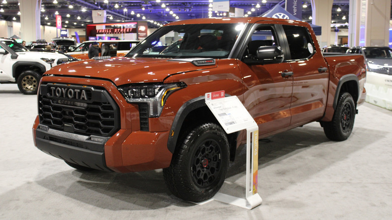 An orange Toyota Tundra on display at a car show.