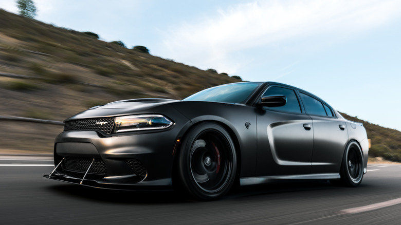 Black Dodge Charger Hellcat racing on highway