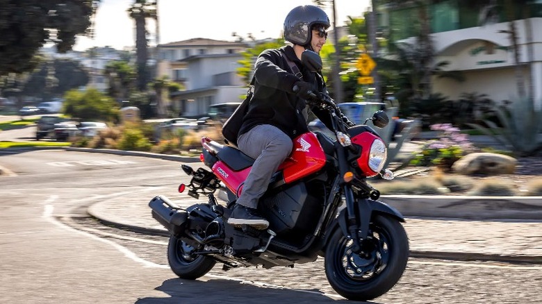 Person turning Honda Navi through roundabout