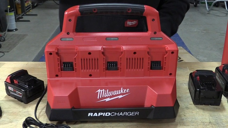 A six-bay Milwaukee rapid charger on a table.