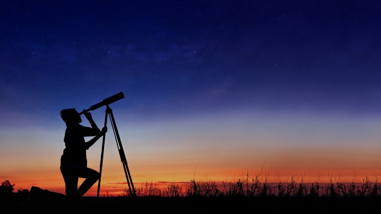 Person looking through telescope