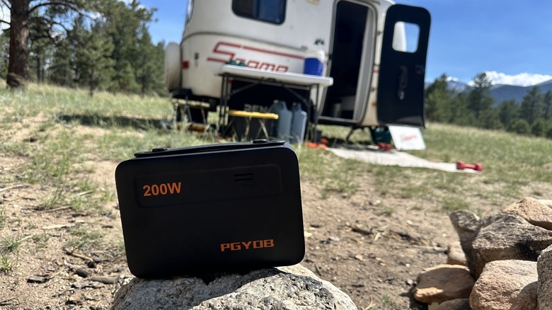 Portable power station on top of rock in front of a travel trailer