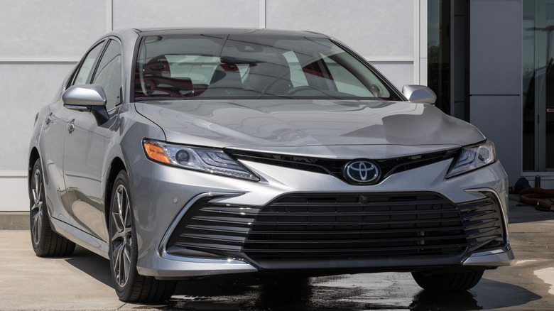 A modern Toyota Camry with a metallic finish parked inside a showroom