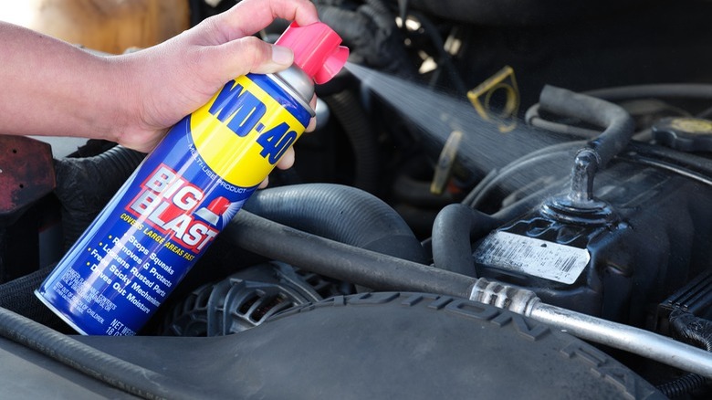 Person using WD-40 in car