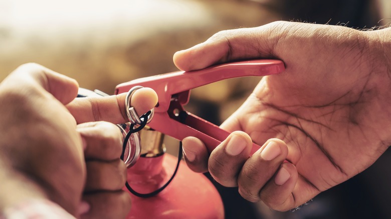 Pulling pin from fire extinguisher