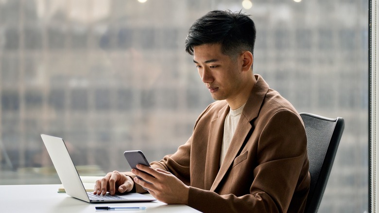 Young man using a computer and smartphone