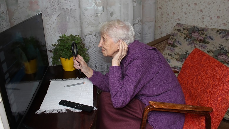 Elderly woman looking at dim TV