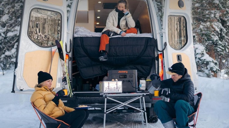 Jackery Explorer 3000 Pro being used in snowy wilderness behind a van