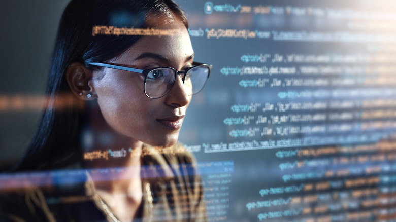 Woman in glasses looking at code