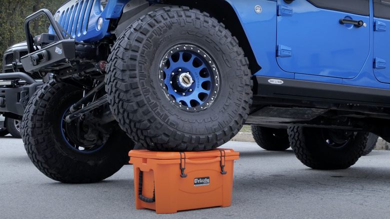 Jeep driving over cooler