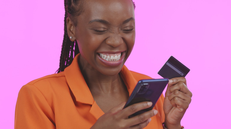 woman holding smartphone credit card