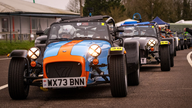 Caterham vehicles lined up at a racing circuit, front-view