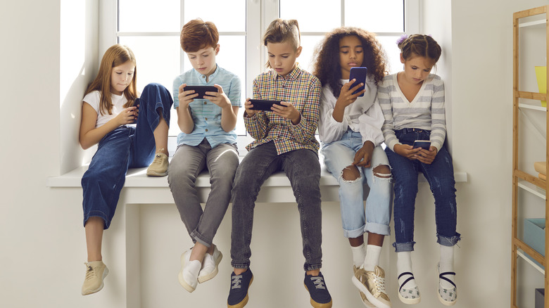 Kids sitting and using smartphones