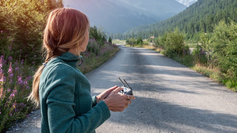 women flying drone mountain trail