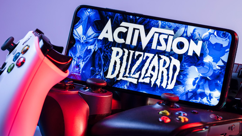 Activision Blizzard logo on phone near controllers