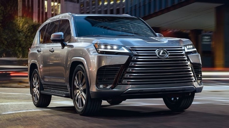 Atomic silver Lexus LX Luxury shown with trees and a building in the background