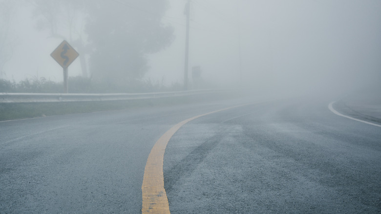 foggy rural highway with road sign