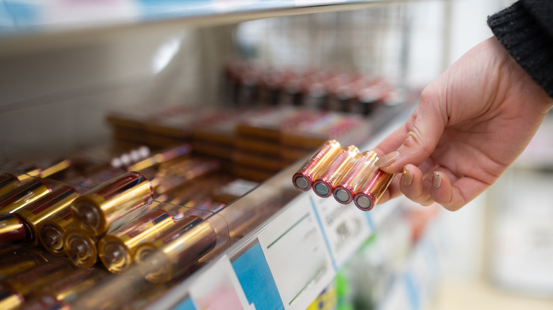 Person looking at batteries after taking them off shelf