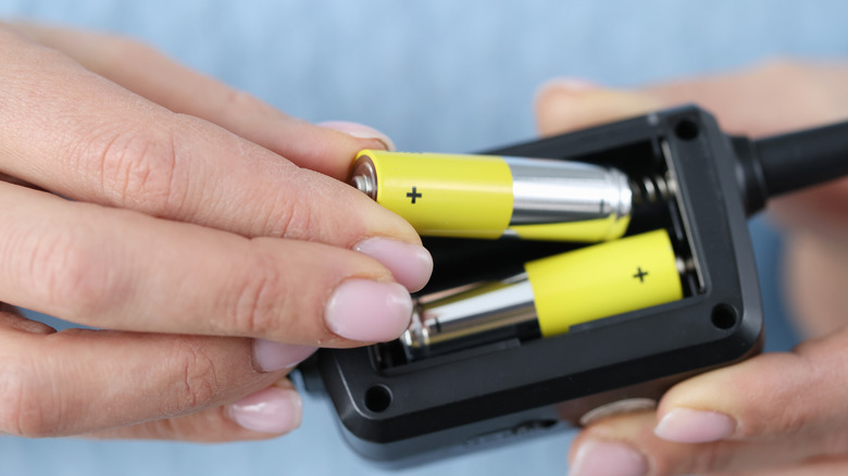 Person putting batteries into a device