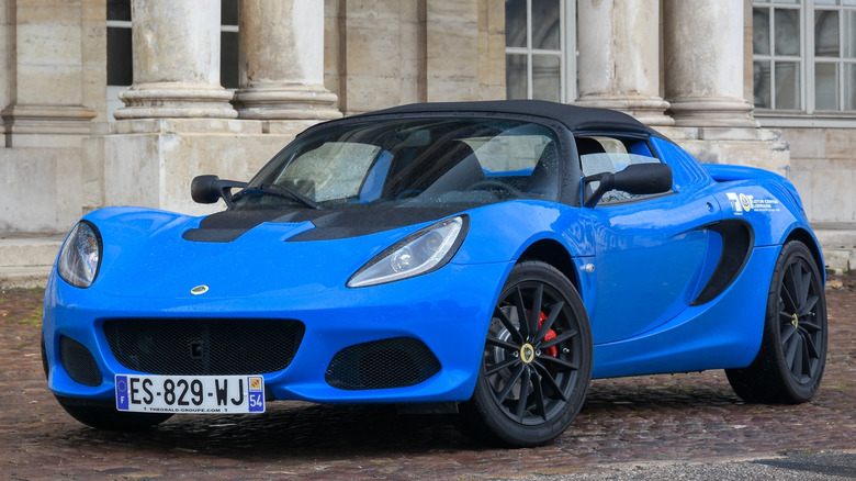 Blue Lotus Elise parked outside fancy building