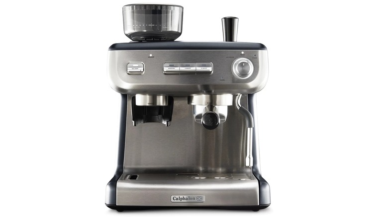 woman in kitchen drinking coffee beside an espresso machine