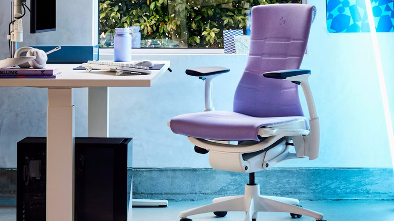 A purple Herman Miller Embody gaming chair next to a white and light brown desk