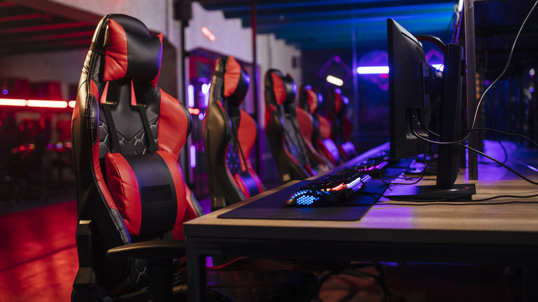 Five gaming chair in a row, each in front of a computer.