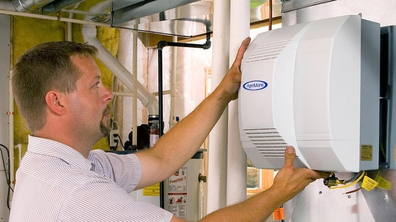 Person installing an AprilAire 700 Whole-House Humidifier.