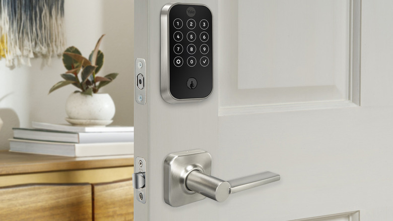 A Yale brand smart lock on a door with a handle