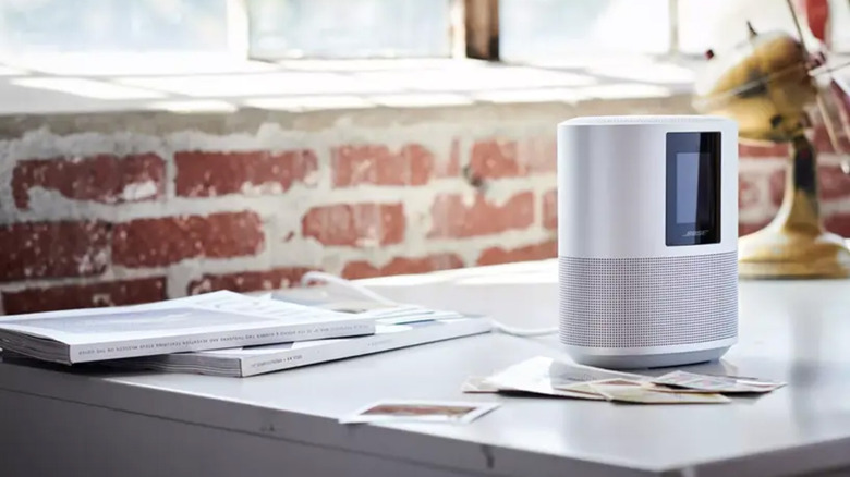 A Bose Portable Smart Speaker on a table with people around