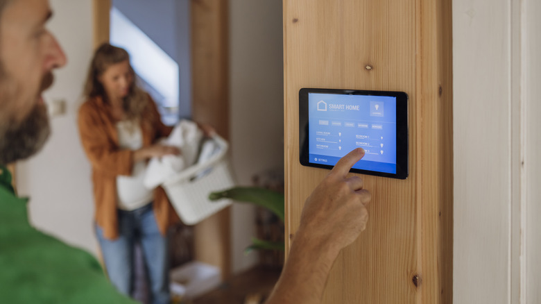 A man adjusting smart-home controls on a tablet