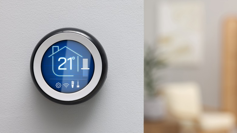 A round smart thermostat on a white wall