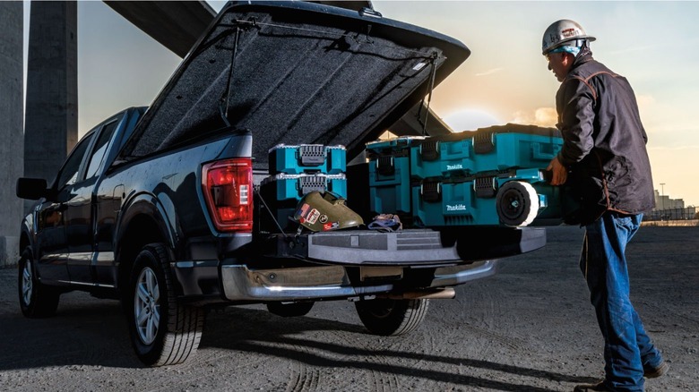 man rolling Makita's rolling chest onto truck