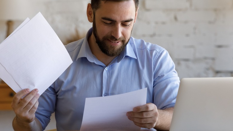 person smiling reading papers