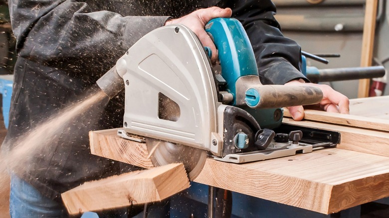 Person cutting wood with circular saw