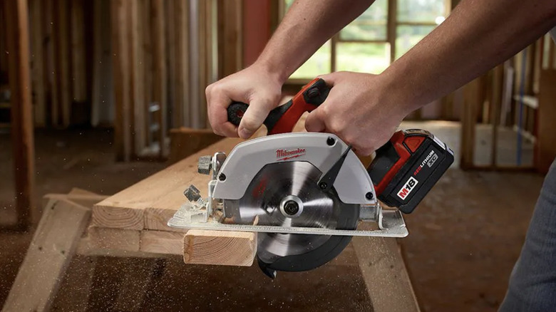 Person using circular saw to cut a piece of wood