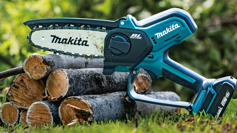 Makita pruning saw sitting on logs