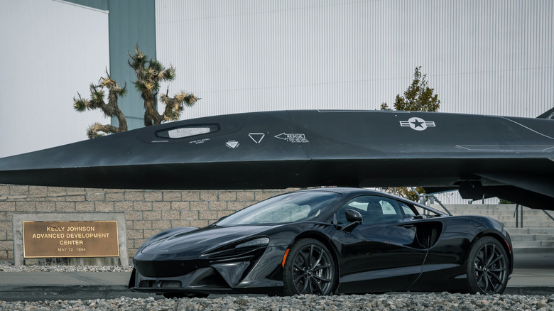 McLaren supercar parked near aircraft