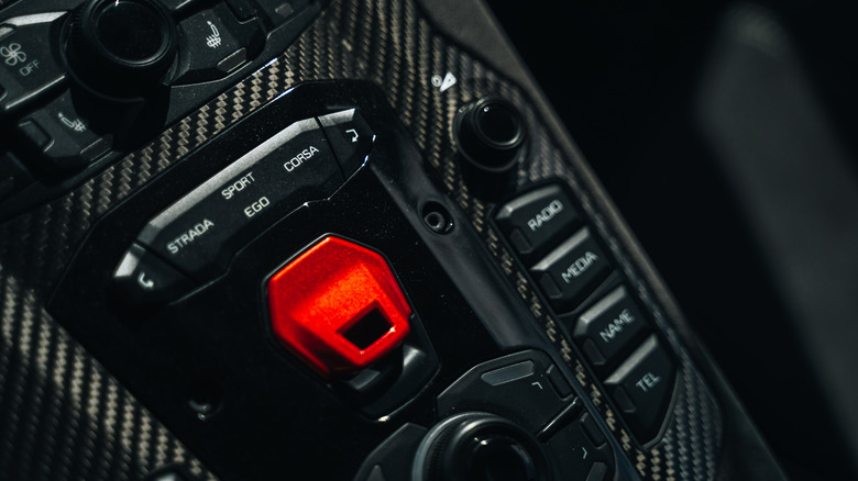 The crimson red engine start button on the Aventador.